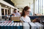 A woman reading a book in a library