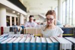 A woman reading a book in a library