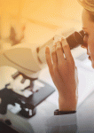 Women researcher looking through microscope